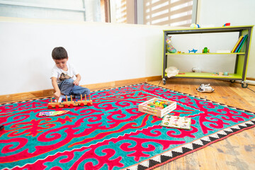 Boy playing with wooden train toy in kindergarten
