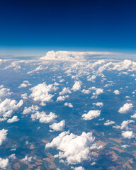 View of abstract shaped white clouds from airplane window