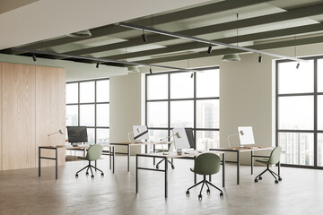 Stylish coworking interior with pc computer and armchairs, window