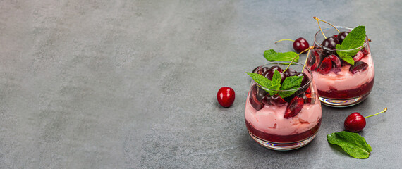 Delicious Italian dessert panna cotta with sweet cherry sauce, fresh berries and mint leaves