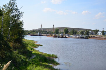 Fototapeta premium Cargo barges stand on the river near the enterprise
