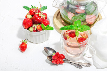 Strawberry tea concept. Good morning concept. Teapot, ripe fruits, healthy beverage