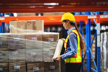 worker wrapping boxes in stretch film in warehouse. stock warehouse logistics concept.