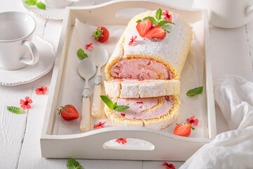 Delicious strawberry roulade with powdered sugar and berry fruits.