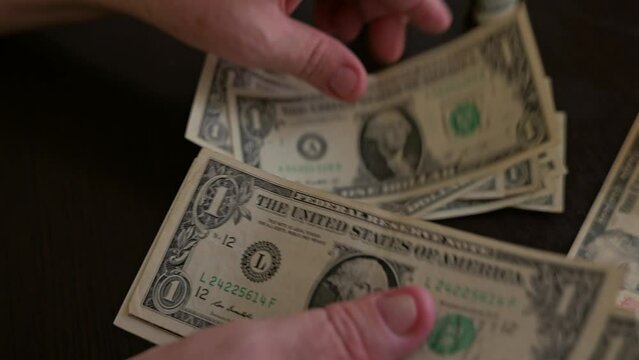 Close-up of men's hands counting small dollar bills. The collapse of the national currency. Exchange rate.