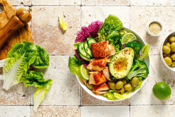 Salmon avocado bowl with broccoli, olives and fresh salad. Healthy food, keto diet, top view