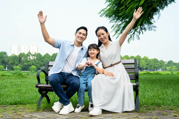 Naklejka na ściany i meble image of asian family playing in the park