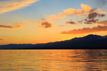 Obraz premium Colorful sea beach over mountains sunrise with deep blue sky and sunbeams. natural background