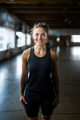 Fototapeta premium Portrait of optimistic attractive muscular woman fitness trainer at the crossfit gym.