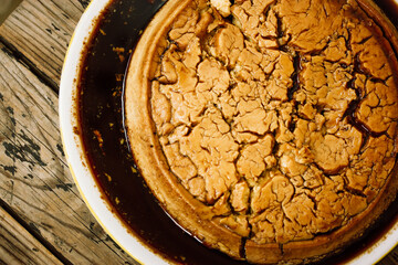 Flan is a dessert dish made with eggs, sugar, milk, topped with caramel. Spanish cuisine dessert. A piece, slice of sweet cake on a platter. A delicious homemade treat on a rustic wooden table flatly