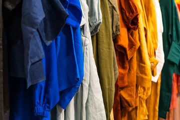 Multi-colored clothes hanging on hangers made of cotton fabric