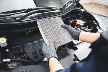 Auto mechanic holding old car air filter pollution to checking cleaning and replacing new for fix heat car air conditioner service maintenance.