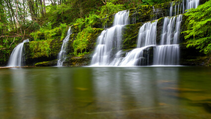 Fototapeta na wymiar Cascading waterfall in a lush green forest (Sgwd y Pannwr, Wales)