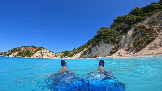 Tourist man having fun in the water at Gidaki Beach on the island of Ithaki or Ithaca in the Ionian sea in the Mediterranean sea of Greece