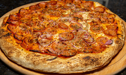 Traditional rustic pizza with pepperoni, black olives, onion and basil