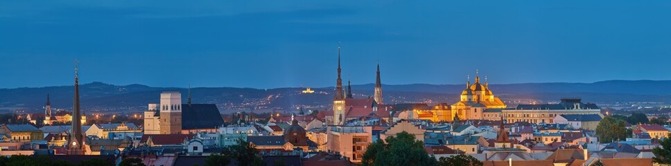 Fototapeta na wymiar Panoramic, very detailed, evening cityscape. Illuminated historical centre of city Olomouc in blue hour, UNESCO site, ancient town and tourist spot in Central Moravia, Czech Republic.
