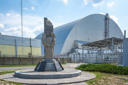 Monument to professionals who protected the world from nuclear disaster and Reactor 4 New Safe Confinement - Chernobyl Exclusion Zone, Ukraine