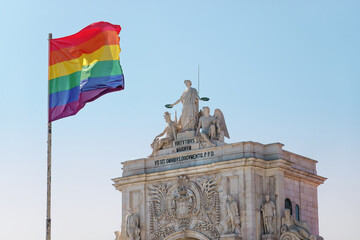 Pride flag in Lisbon, Portugal. Rainbow flag, LGBT flag on Praça do Comércio, Commerce square in front of Rua Augusta Arch, Arco da Rua Augusta. Pride month in June. 