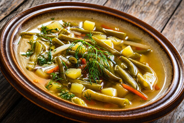 Green bean soup on wooden table
