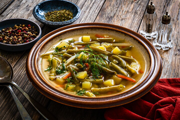 Green bean soup on wooden table
