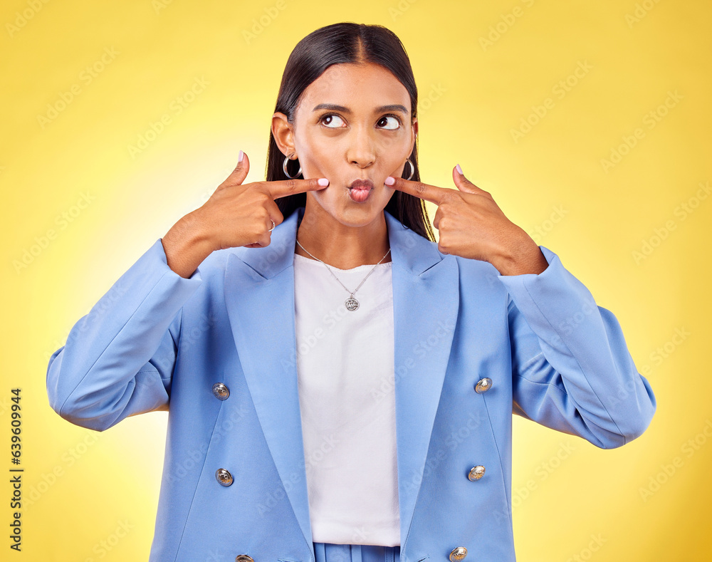 Sticker Face, fingers on cheek and a woman in studio for positive attitude, dimples and emoji. Indian model person or student thinking of fashion, comic and funny face or silly mood on a yellow background