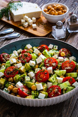 Fresh vegetable salad with feta cheese on wooden table
