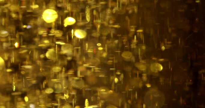 Gold abstract futuristic sparkling glitter background. Bright gold particles fly in different directions