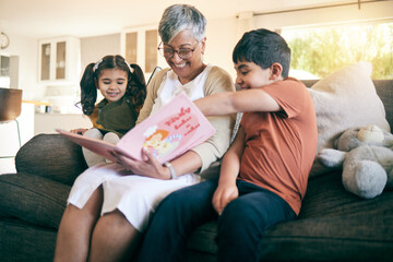 Happy kids, smile or grandmother reading a book for learning, education or storytelling on sofa at home. Family, senior or grandma with children siblings for a fantasy story to enjoy bonding together