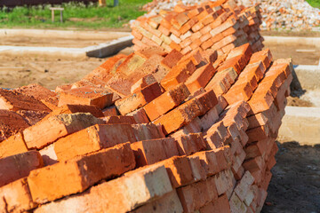 Red bricks stacked at a construction site. Construction of brick houses. Material for the construction of walls and partitions