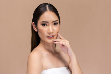 Beautiful Asian woman touching eyebrow smile with clean and fresh skin Happiness  with positive emotional,isolated on Beige background,Beauty Cosmetics and spa Facial treatment Concept.