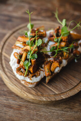 Appetizing bruschetta with cream cheese, microgreens and mushrooms.