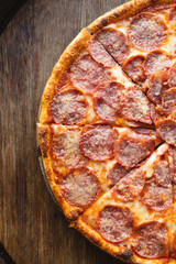 Appetizing pizza with salami and cheese. Slice of pizza with elastic cheese
