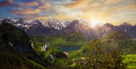 Alpine mountain view in the evening light on a sunny day in summer at Neuschwanstein Castle and the Alpsee lake in Allgau, Germany with a view of the Allgau Alps - obrazy, fototapety, plakaty