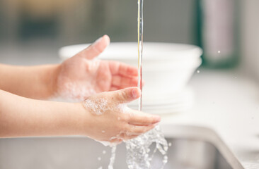Child, washing hands and kitchen with foam in closeup for health, safety and stop bacteria in...