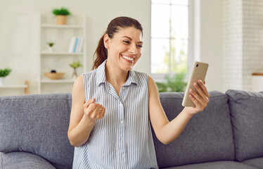 Casual woman on couch look modern mobile cellular phone screen happy smiling face expression...