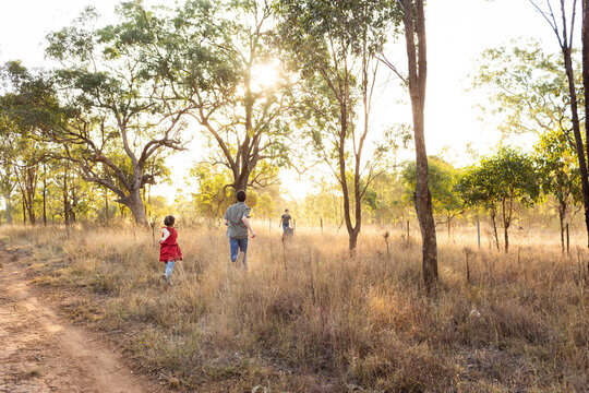 Aussie country kids running through dusty paddock in rural Australia