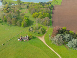 Aerial view of a typical English cricket pavilion seen near a ploughed field. Seen just before a...