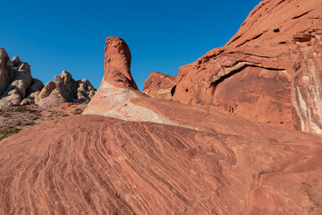 Scenic view of striated red and white rock formations along the White Domes Hiking Trail in Valley of Fire State Park in Mojave desert, Nevada, USA. Unique natural landmark shaped like a spire