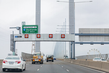 Grey cloudy day with traffic crossing Bolte Bridge over the Yarra River