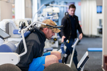 exercise therapy equipment at physiotherapy clinic with man using it at treatment