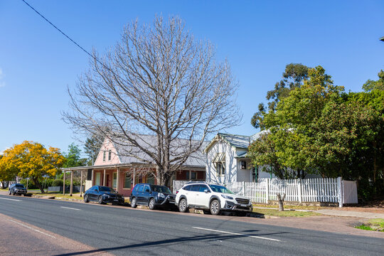 Country town street busy with parked cars near old style historic buildings