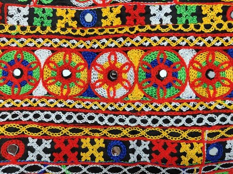 kanch kachhi work art. fabric hand work design on the traditional cloth. background. Indian art work of multicolor. Kuchhi bharat, hand craft with threads and niddle. 