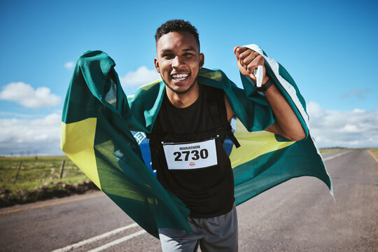 Portrait, fitness and flag of Brazil with a man runner on a street in nature for motivation or success. Face, winner celebration or health with an athlete cheering during cardio or endurance training
