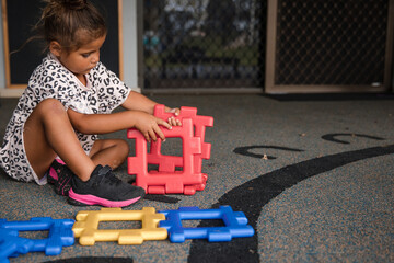 Young Aboriginal girl playing at preschool with plastic toy