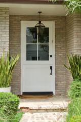 white dutch door at entrance of brick building