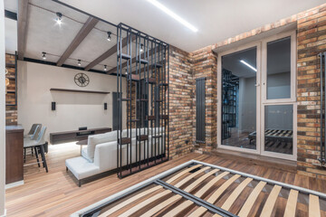 Amazing interior design of the studio apartment. Brickwork walls, high steel batteries. Stylish furniture.