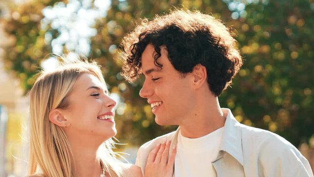 Smiling beautiful woman and her handsome boyfriend. Woman in casual summer clothes. Happy cheerful couple. They posing in the street at sunny day and have fun. Teenagers outdoors 