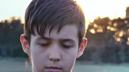 Intense Gaze: Close-Up Portrait of a Brooding and Sad Boy in Nature