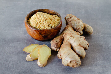 Ginger root and ginger powder on grey background