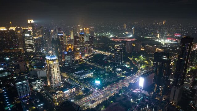 night illuminated jakarta city downtown stadium traffic street aerial panorama 4k timelapse indonesia